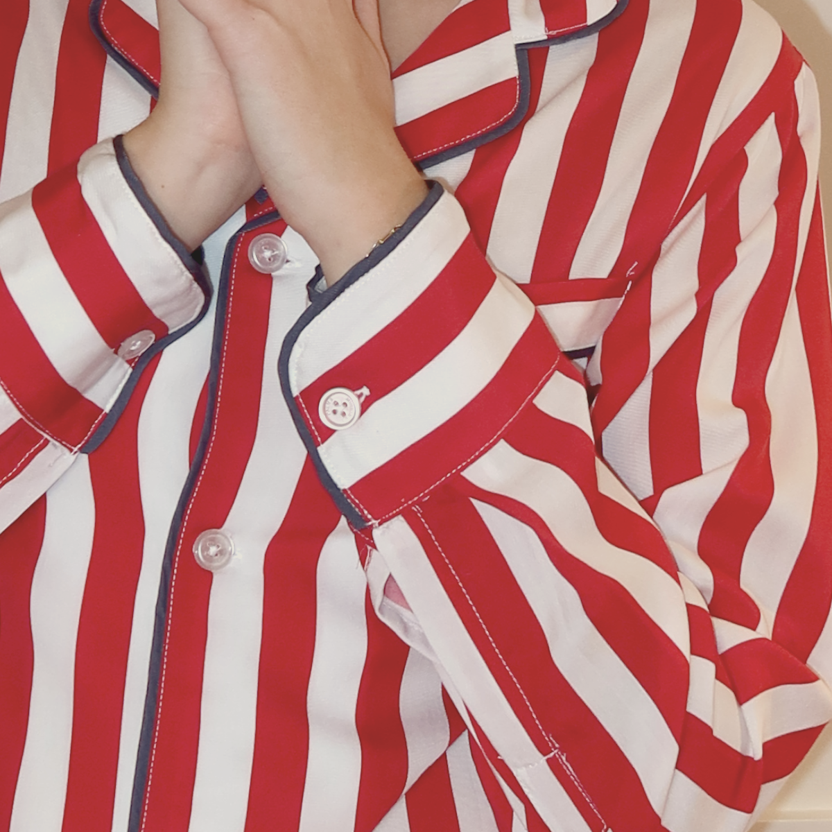 Close-up of women’s red striped pajama set with contrast piping by Midnight Palms, made in Canada
